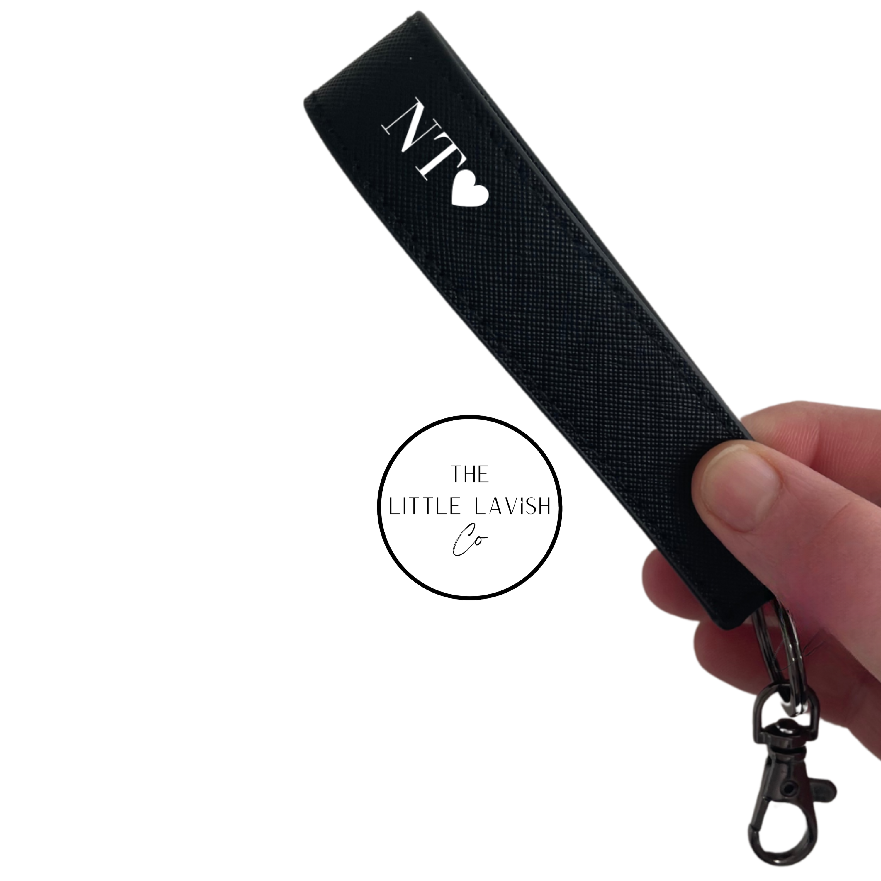 Black lanyard with 'NT' logo held by a hand on a white background, branded 'The Little Lavish Co'.